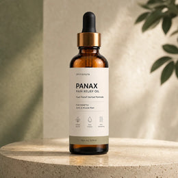 Skinsoura Panax Pain Relief Oil amber bottle on travertine in a botanical setting